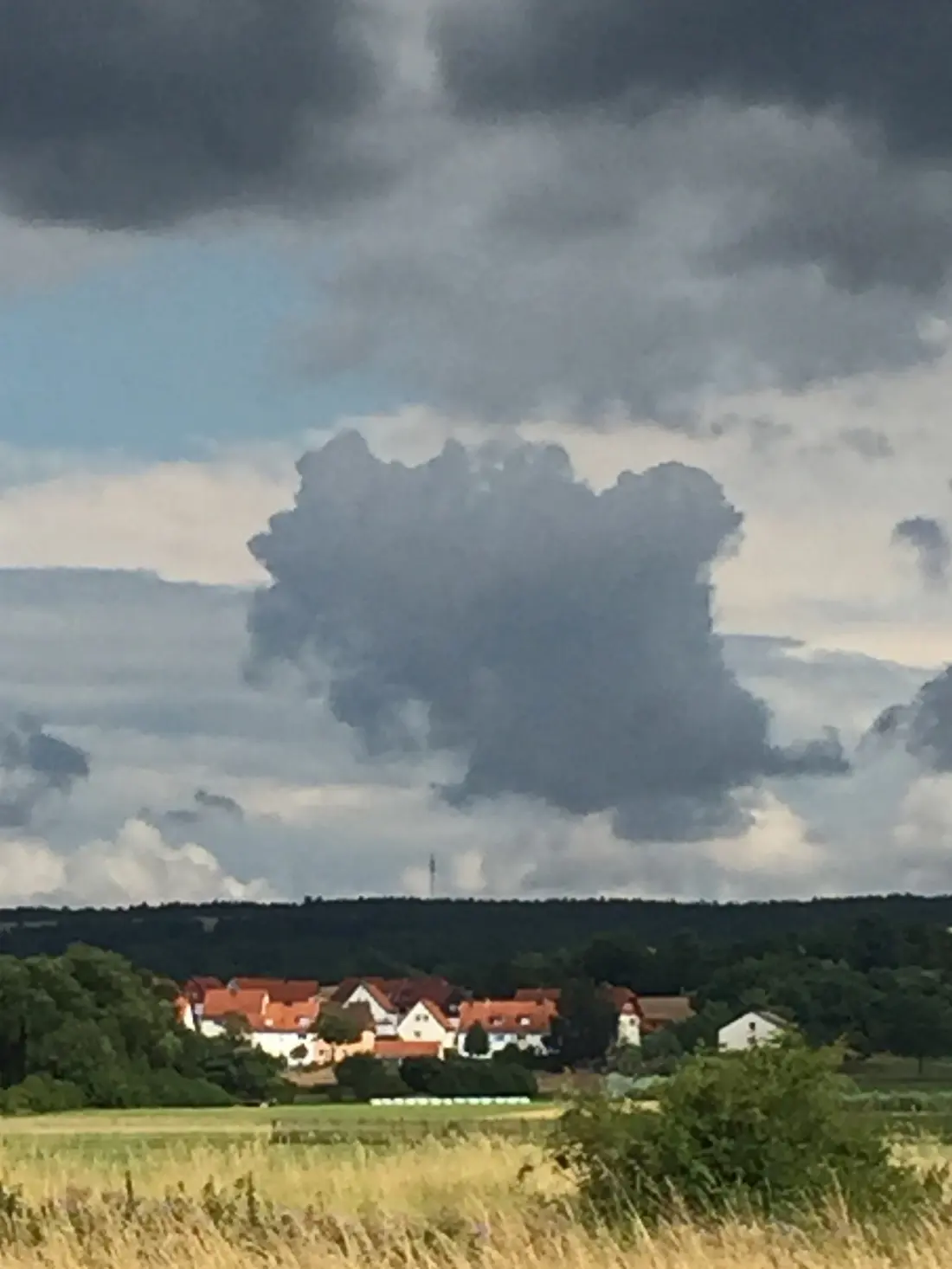 Wolke droht über Dorf in der Sonne