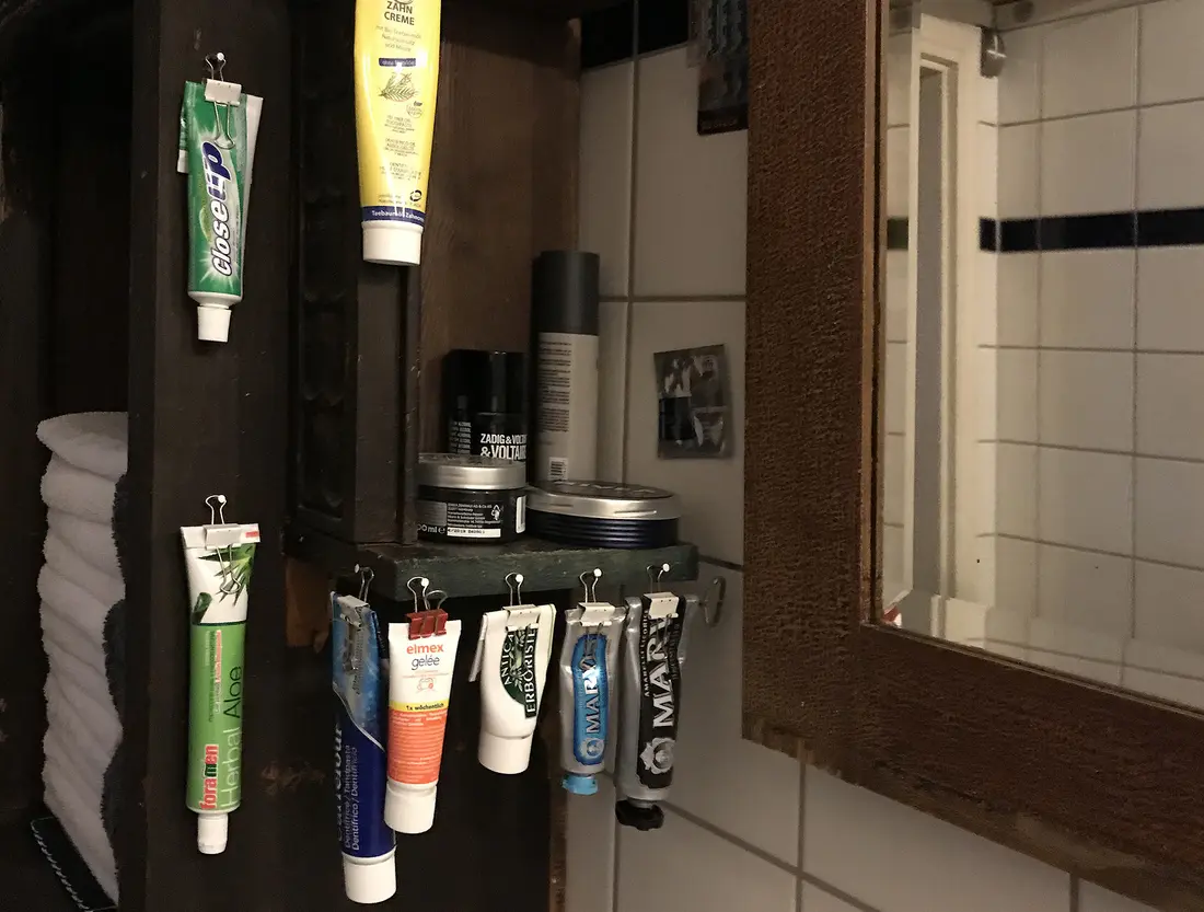 im Badezimmer an Klammern aufgehängte Tuben