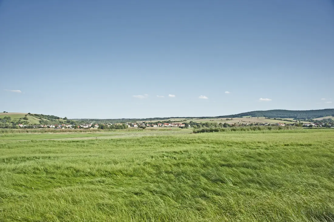 Viel flaches Land mit einem Dörfchen am Horizont