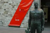 Statue vor Ausstellungsplakat