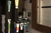 im Badezimmer an Klammern aufgehängte Tuben