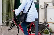 Beim Fahrradfahren wird das Handy am Ohr vom Kopftuch gehalten