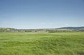 Viel flaches Land mit einem Dörfchen am Horizont